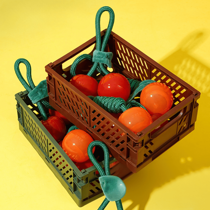 Toy crate with red and orange balls on a yellow background