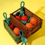 Toy crate with red and orange balls on a yellow background